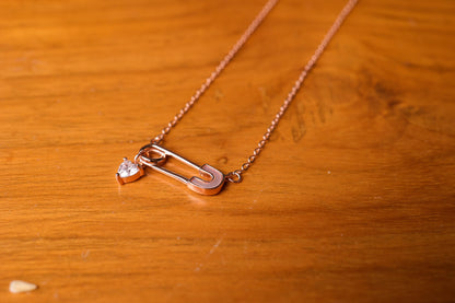 Safety pin with a heart charm pendant and chain